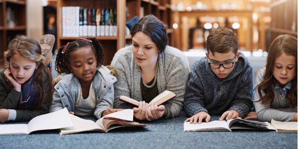 teacher and reading to four kids at library