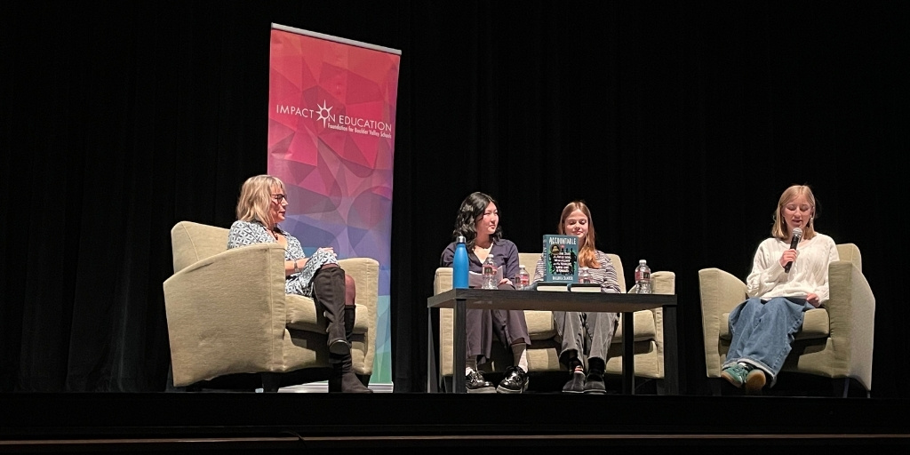 Panel of students and author on stage having a conversation